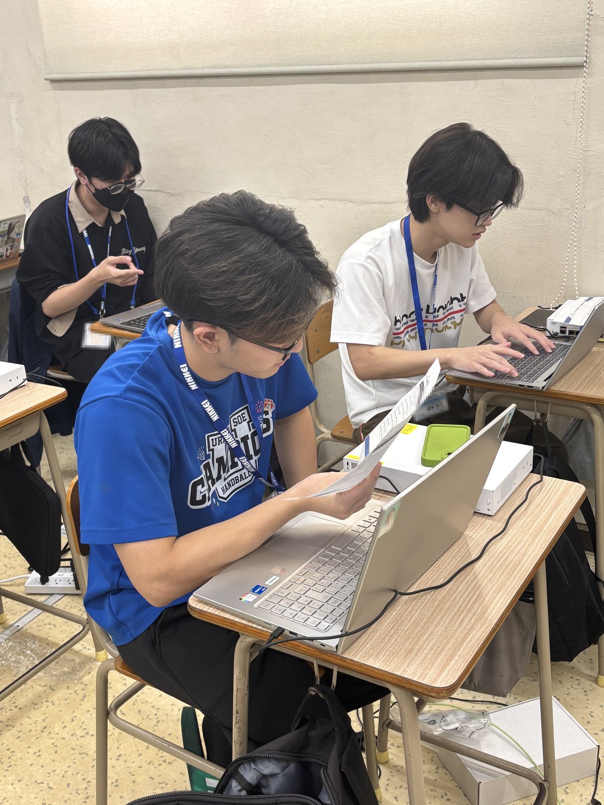 (写真)ネットワーク機器をつなぎながら設定を進める授業の様子