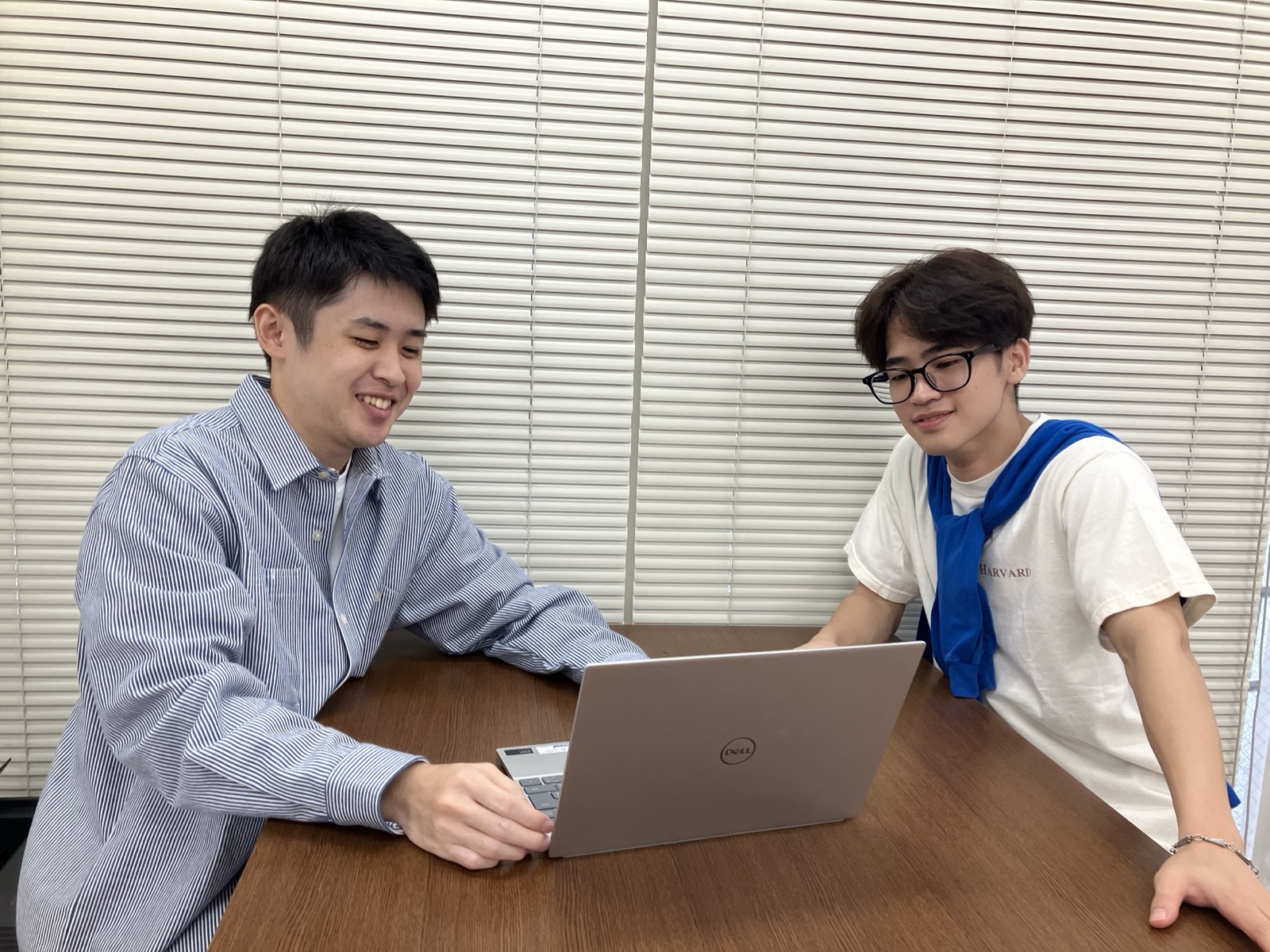 (写真)友人とノートパソコンをのぞき込みながら課題を進めるYさん